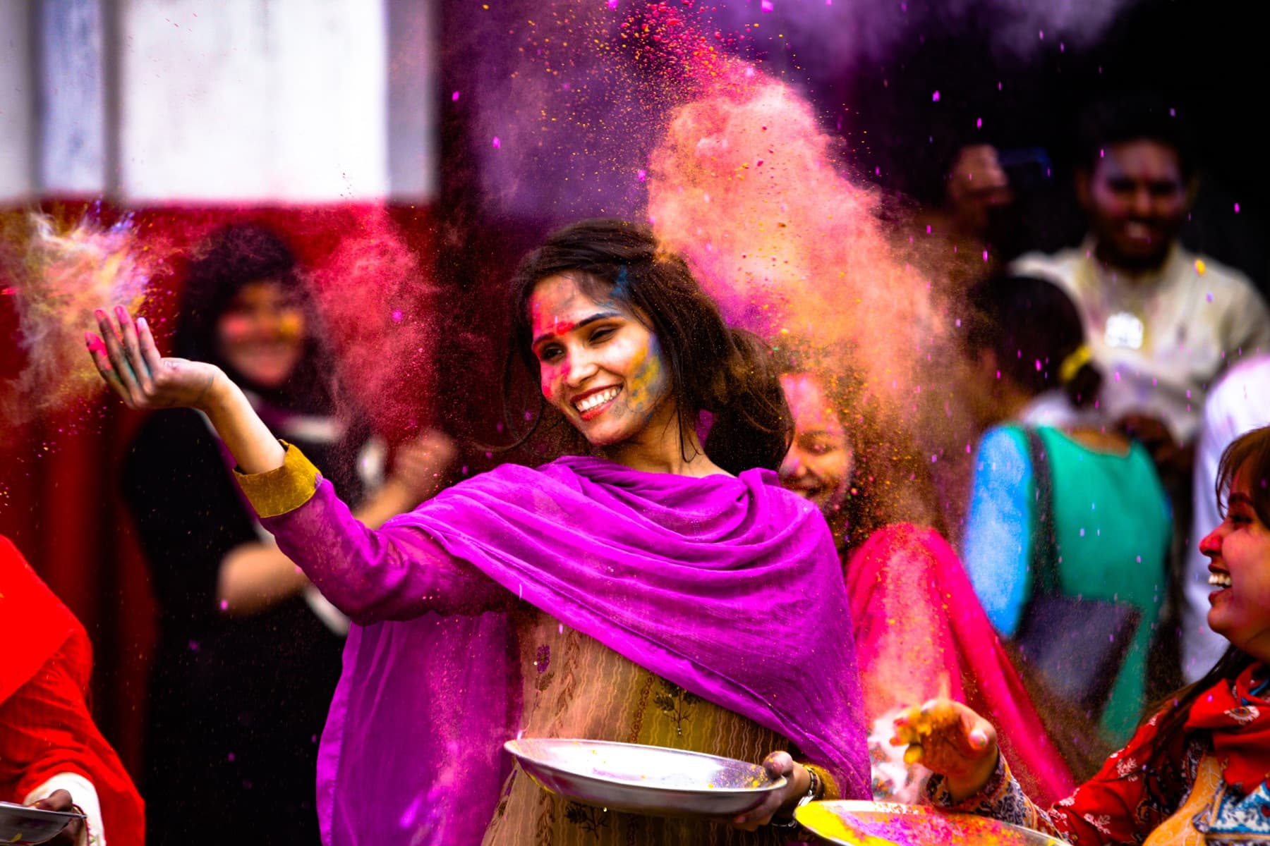 Travelers celebrating together in a cloud of color